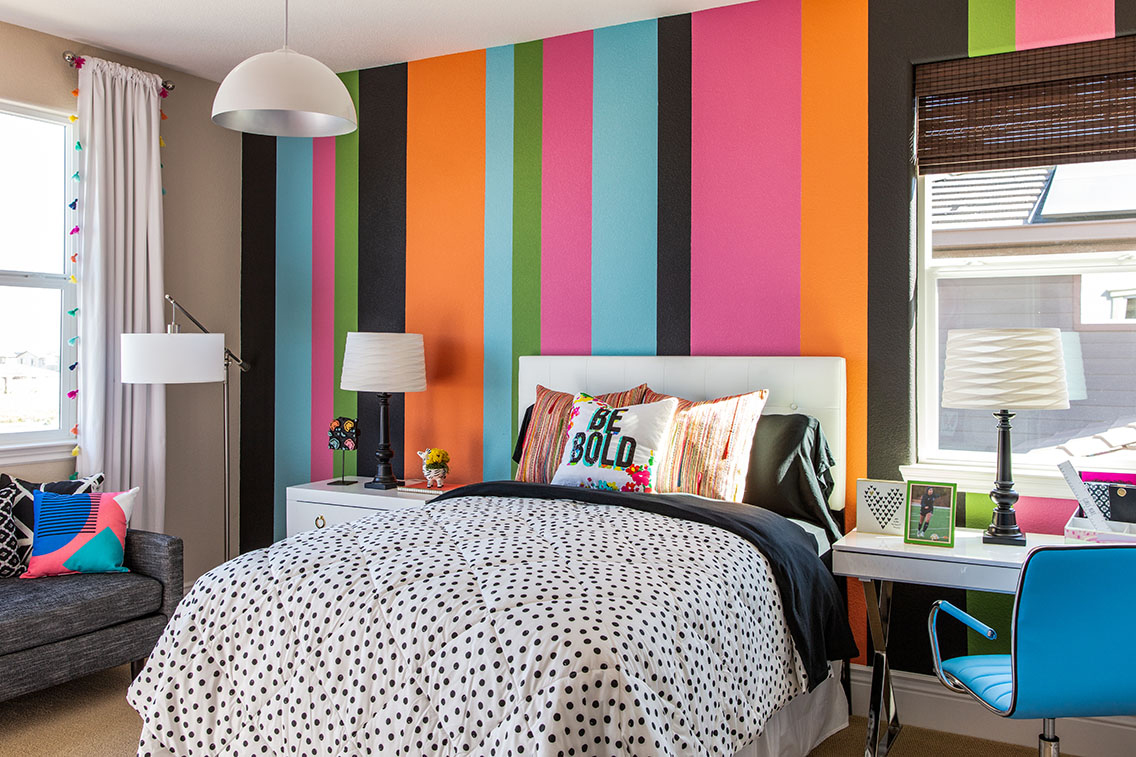 colorful kids bedroom with multi color walls and floral bedding